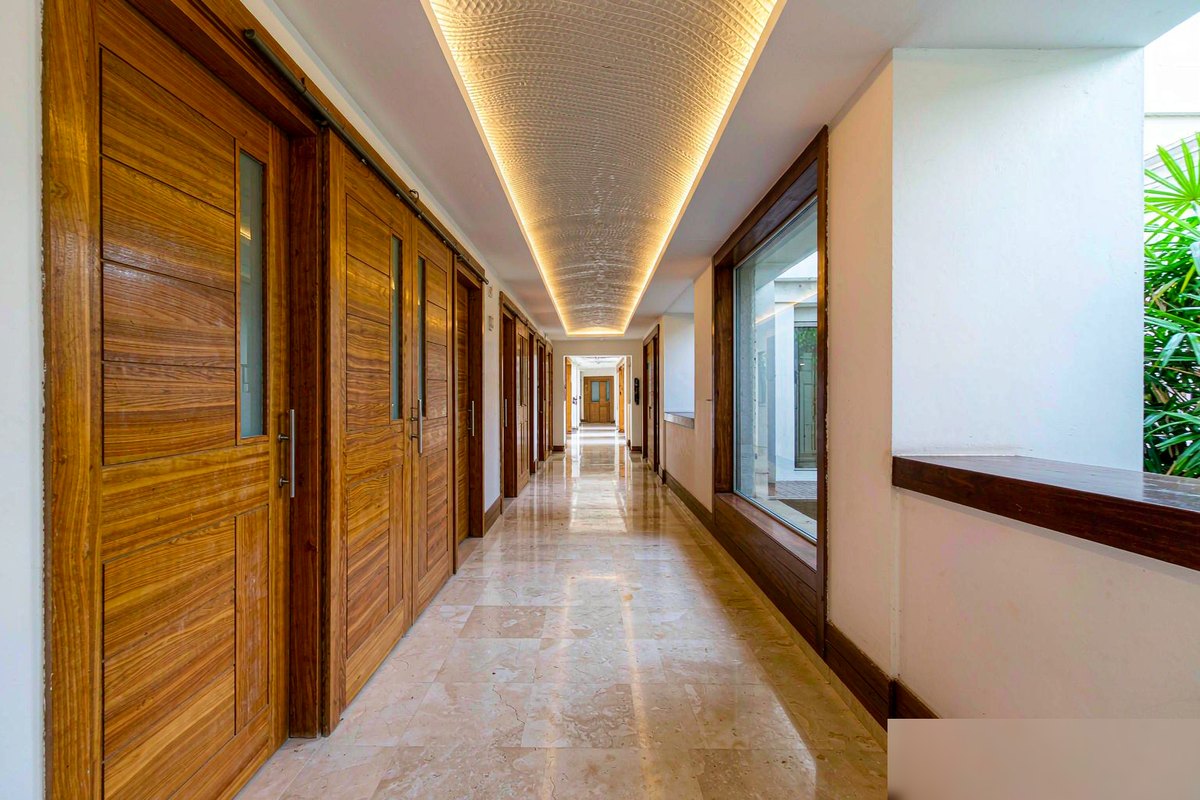 Row of wood-grain WPC doors along a hotel corridor in a hot and humid climate